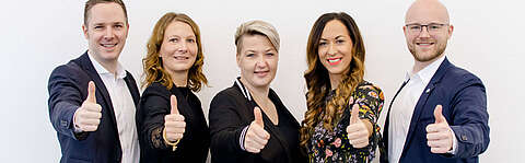 Engagiertes Team zeigt Daumen nach oben
