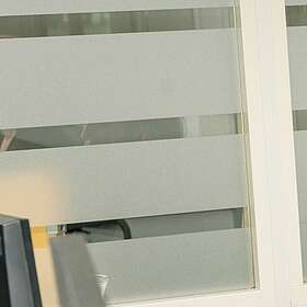 Mitarbeiterin sitzt am Arbeitsplatz und spricht über Headset.