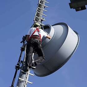 Richtfunkantenne mit arbeitetem Mitarbeiter